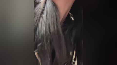 A close-up video of a person's neck and shoulders, wearing a black leather jacket with a fur collar. The background is dark, emphasizing the textures and details of the jacket.