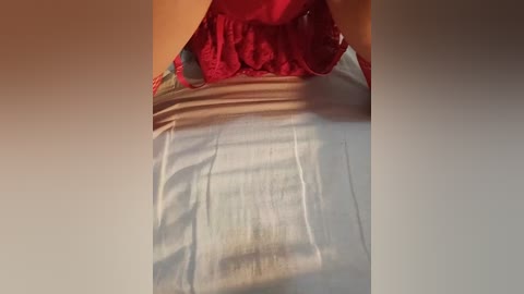 Video of a woman's upper torso in a sleeveless white top with a red ruffled hem, showcasing smooth skin and a subtle shadow effect.