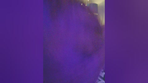 A blurry, dimly lit video showing a purple hue, with indistinct figures in the background, suggesting a party or crowded event.