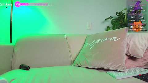 Video of a beige couch with a green light illuminating it, featuring a pillow with \"Napoli\" embroidered in white, and a controller on the left.