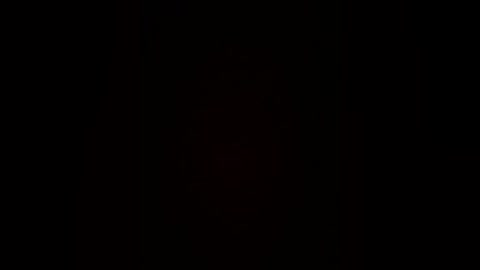 A video of a black background with a faint, indistinct shape resembling a human figure in the center, possibly male, with subtle, indistinguishable features. The image has a minimalistic and mysterious feel.