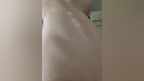 A video showing a close-up of a person's bare back, with light skin tone, visible dimples, and a slightly curved spine. The background is blurred, suggesting an indoor setting with muted colors.