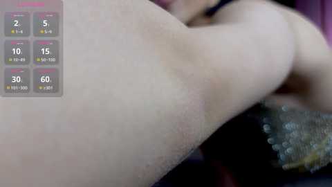 Video of a close-up of a woman's bare, fair-skinned, smooth thigh, with a side view of her body and a blurred face in the background. A digital thermometer screen displays \"30\" in the upper left corner.