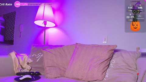 Video of a cozy living room with purple lighting, beige couch, Halloween pumpkin decoration, and gaming controller on the couch.