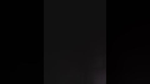 A video of a black rectangle against a black background, creating a stark, minimalist composition with subtle, indistinct shadows and no discernible objects or details.