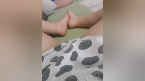 A video of a person's legs and feet, wearing patterned shorts, with a blurred background, focusing on the lower body.