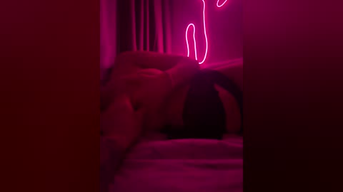 A dimly lit, intimate video of a nude woman with fair skin, lying on a bed, featuring neon pink lighting and blurred background.