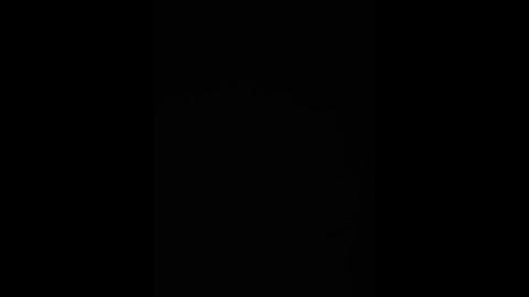 A minimalist, black-and-white video featuring a stark contrast between a dark background and a faint, vertical line of light running from the top right to the bottom left, creating a subtle sense of depth and movement.