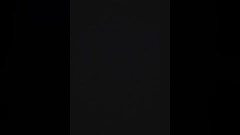 A video of a black-and-white striped flag, with the stripes running vertically, set against a black background. The flag has a textured, slightly rough appearance.