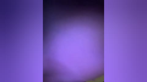 This image is a blurred, abstract piece featuring a gradient of purple hues with a central bright white light. The background is a soft, indistinct blur, suggesting an ethereal, dreamlike atmosphere.