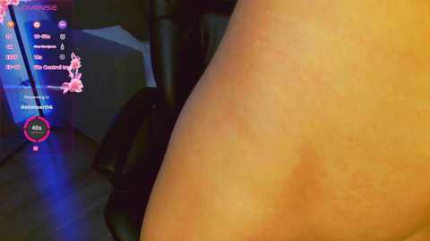 Video of a person's arm with a visible sunburn, in a dimly lit room with gaming peripherals and a chair.