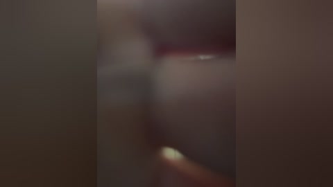 The image is a blurred, close-up video of a person's torso, likely female, with visible skin tone and slight redness, possibly from sun exposure. The background is indistinct, creating an ambiguous setting.