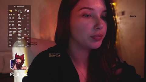 A video of a young woman with long brown hair, wearing a black jacket, captured in a dimly lit room with warm lighting. The image features a virtual overlay of a cartoon dog.