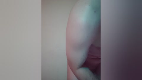 A close-up video of a nude person, possibly a woman, bent over, revealing the curve of their buttocks and the back of their thighs. The image is blurry, with a soft focus, and has a muted color palette.