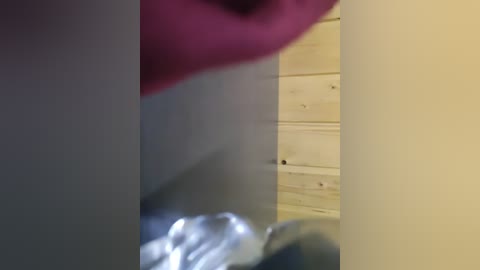 Video of a blurred, close-up view of a person's face, lips, and part of a wooden wall. The background is dimly lit, with a hint of a metallic object.