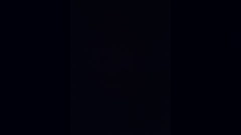 A black and white video with a stark, monochromatic aesthetic. The image features a single, vertical, thin, black line running from the top left to the bottom right, dividing the frame into two equal halves.