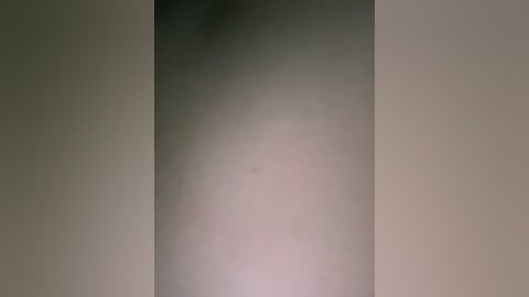 Video of a tall, vertical, cylindrical object, possibly a column or pillar, with a soft, diffused lighting creating a smooth, gradient transition from light to dark. The background is a plain, neutral color, likely beige or off-white, contributing to the minimalist aesthetic.