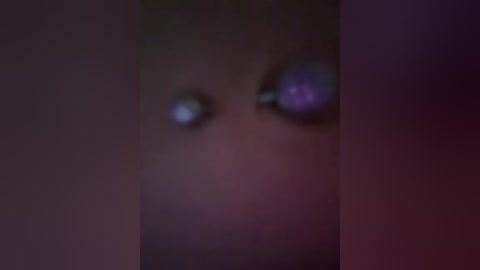 A blurred video featuring two large, glowing, purple eyes in the center against a dark, indistinct background, creating a mysterious, eerie atmosphere.