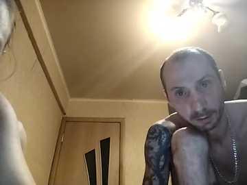 A video of a shirtless, muscular man with a bald head and tattoos, looking surprised and slightly annoyed, taken indoors.