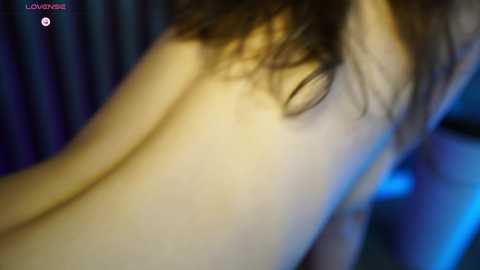 A blurred video showing a pale-skinned woman with wet, wavy brown hair, partially naked, leaning forward, with a blue-tinted background. The image is titled \"LOVE DIVINE.\