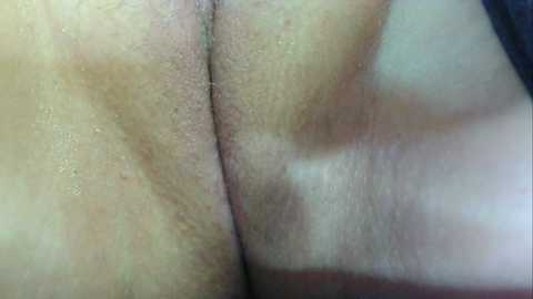 A close-up video of a woman's lower back and buttocks, showcasing light skin with visible pores and natural texture. The image is highly detailed, focusing on the skin's natural contours and subtle shadows.