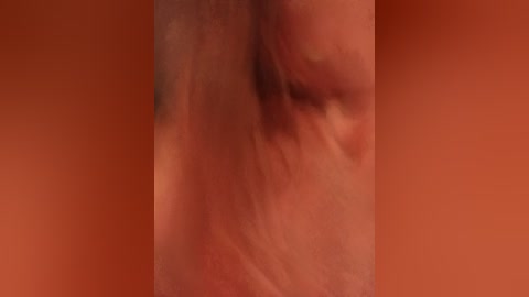 A close-up video of a human ear, partially covered by a pinkish-orange background, showing detailed skin texture and slight folds.