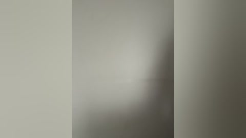 A soft-focus video of a minimalist, beige wall with a slight shadow and texture, creating a serene, muted ambiance.