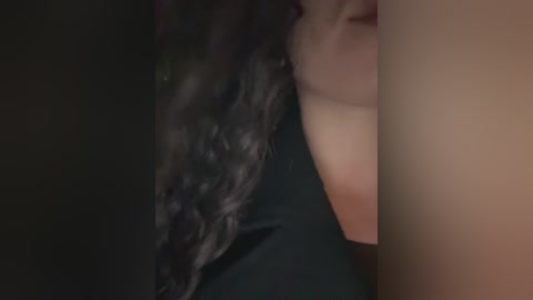 Video of a close-up of a woman's face, partially visible, with long, wavy black hair, and a fair complexion. She is lying down, her expression indiscernible.