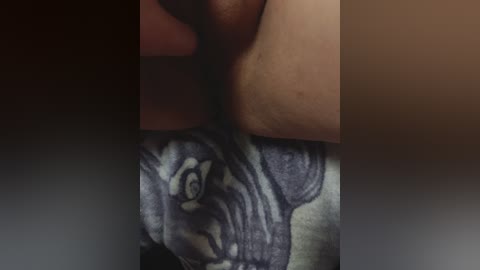 A close-up video shows a tattoo on a person's thigh. The tattoo depicts a stylized, cartoon-like dog with large eyes and a smiling expression, rendered in dark blue ink against a light grey background.