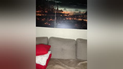 Video of a cozy living room with a beige sectional sofa, a red and white Christmas pillow, and a large cityscape mural on the wall. The room is warmly lit.
