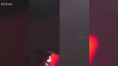 Video of three identical cylindrical objects in a dark room. Two objects have red lights on the bottom, while the third is unlit. The lighting is dim, creating a moody atmosphere.