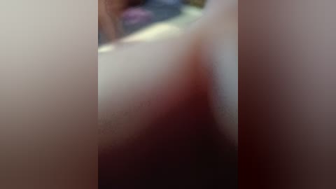 A blurry video depicts a close-up of a person's lower abdomen, showing a reddish-brown stain and indistinct clothing, possibly denim, with a blurred background.