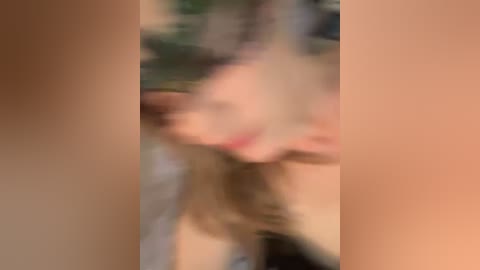 Blurry video of a nude woman with long blonde hair, possibly in a sexual act, partially obscured by close-up vertical frames.
