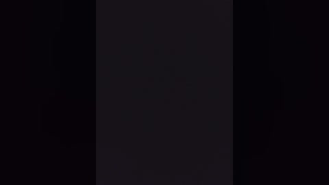 A video of a dark, monochromatic image, possibly a silhouette or abstract art piece, with a vertical black line bisecting the frame, suggesting a minimalist, contemporary style. The background is entirely black, providing a stark contrast to the central vertical line.