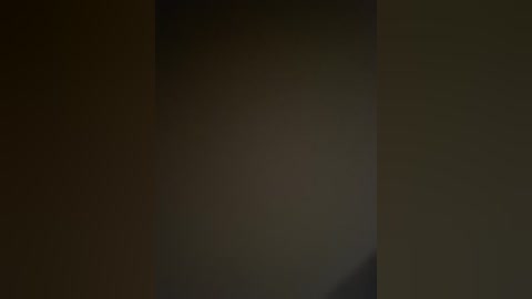 Video of a dimly lit room with a dark, blurry figure standing in the background, creating a mysterious and ominous atmosphere.