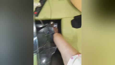 Video of a person's hand inserting a USB drive into a green laptop, with a blurred background.
