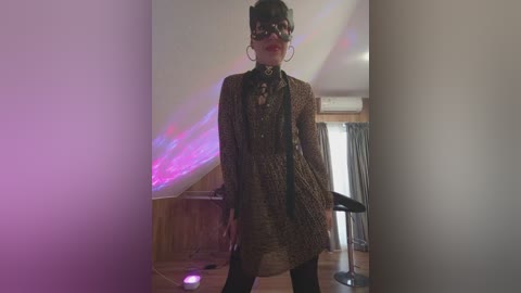 Video of a person with short dark hair, wearing a leopard-print jacket, black shirt, and black pants, standing in a dimly lit room with purple and pink LED lights, wooden floor, and a black bar stool in the background.