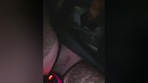 A dimly lit, close-up video of a person lying on their back, wearing black lingerie, with a red glow in the foreground, creating a dramatic, mysterious ambiance.