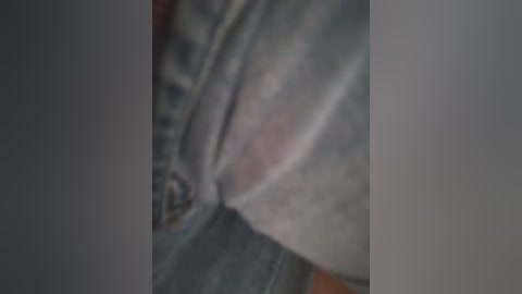 A blurry, close-up video of a person's genital area, showing a penis and testicles. The skin tone is light, with visible pubic hair. The background is out of focus, making it difficult to discern specific details.