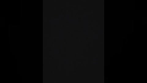 A minimalist, monochromatic digital drawing featuring a vertical, dark gray rectangle set against a pitch-black background, with no discernible textures or objects.