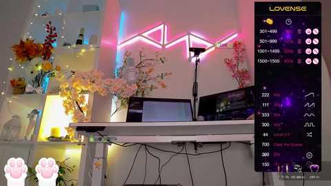 A vibrant video of a modern living room with neon triangle lights, white shelves adorned with flowers, a computer setup, and a colorful screen displaying a digital menu.