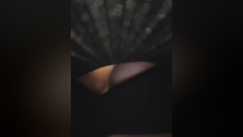 A close-up video of a woman's face with large, slightly asymmetrical, and drooping eyelids, giving a tired or sleepy appearance. The background is dark and blurred, focusing attention on the eyes.