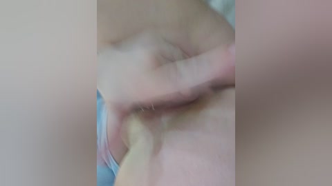 Video of a close-up of a person's hand, fingers gently touching their lips. Skin tone is light, with a slight blurring effect. The background is indistinct, focusing on the intimate gesture.