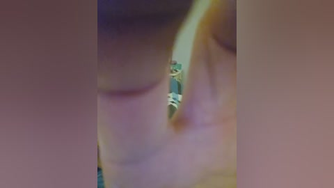 A close-up video of a person's profile, showing an eye with a green contact lens, set against a blurred background. The skin tone is light, and the individual appears to be looking down.