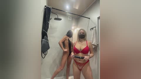 Video of a curvy, blonde woman in a red lace bra and panties, holding a straightener in a modern, well-lit bathroom.