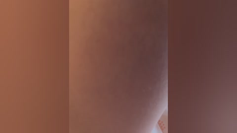 A video showcasing a close-up view of a person's bare back, with a smooth, light brown skin tone, partially visible in the center frame.