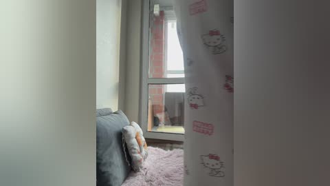 Video of a cozy, sunlit room with a white curtain featuring My Melody patterns, a plush My Melody pillow, and a soft pink rug.