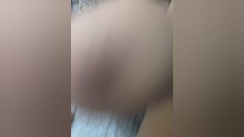 Video of a close-up, blurred human eye, partially obscured by a hand holding a smartphone, taken in a dimly lit room. The eye's iris and pupil are visible, but the subject's face is out of focus.