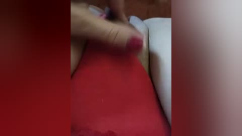 A blurry, red-filtered video captures a close-up of a hand with a manicured nail pressing against a person's exposed stomach, likely in a sexual context.