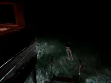 Video of a dark, dimly lit room with a small pool in the center. A person in a black wetsuit is swimming towards the camera, creating ripples. The room has a red light on the left wall, casting a warm glow.